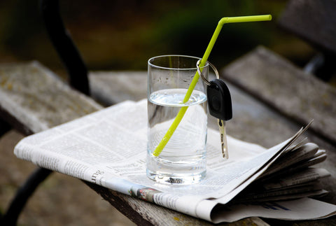 Glass of water for the designated driver on a night out. Straw with car keys hanging from it.